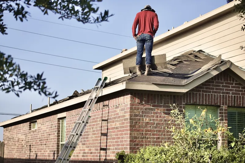 Professional roofer working on a residential roof in Whigville